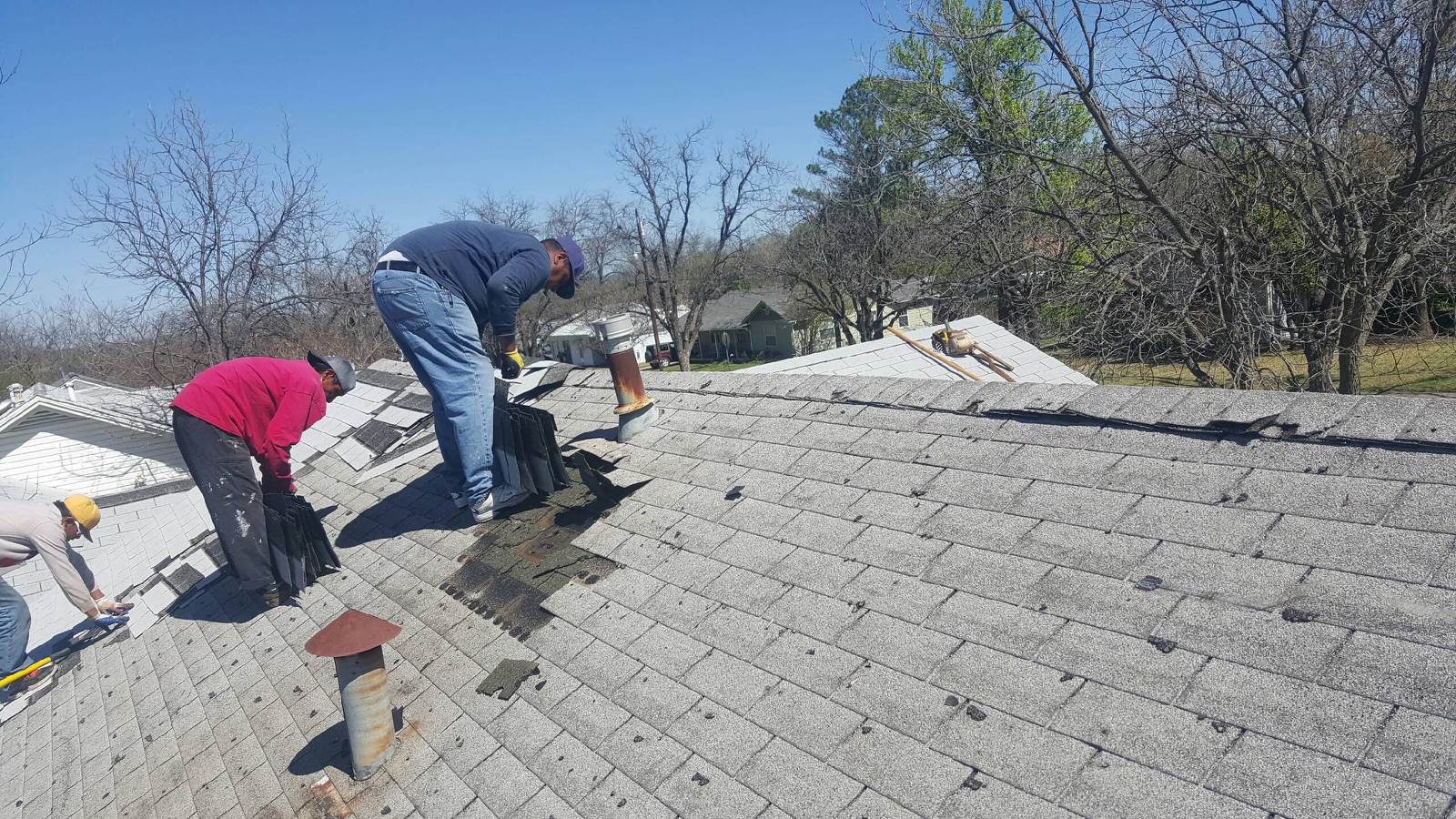Heritage Roofing crew tearing off old residential roof in Central Texas