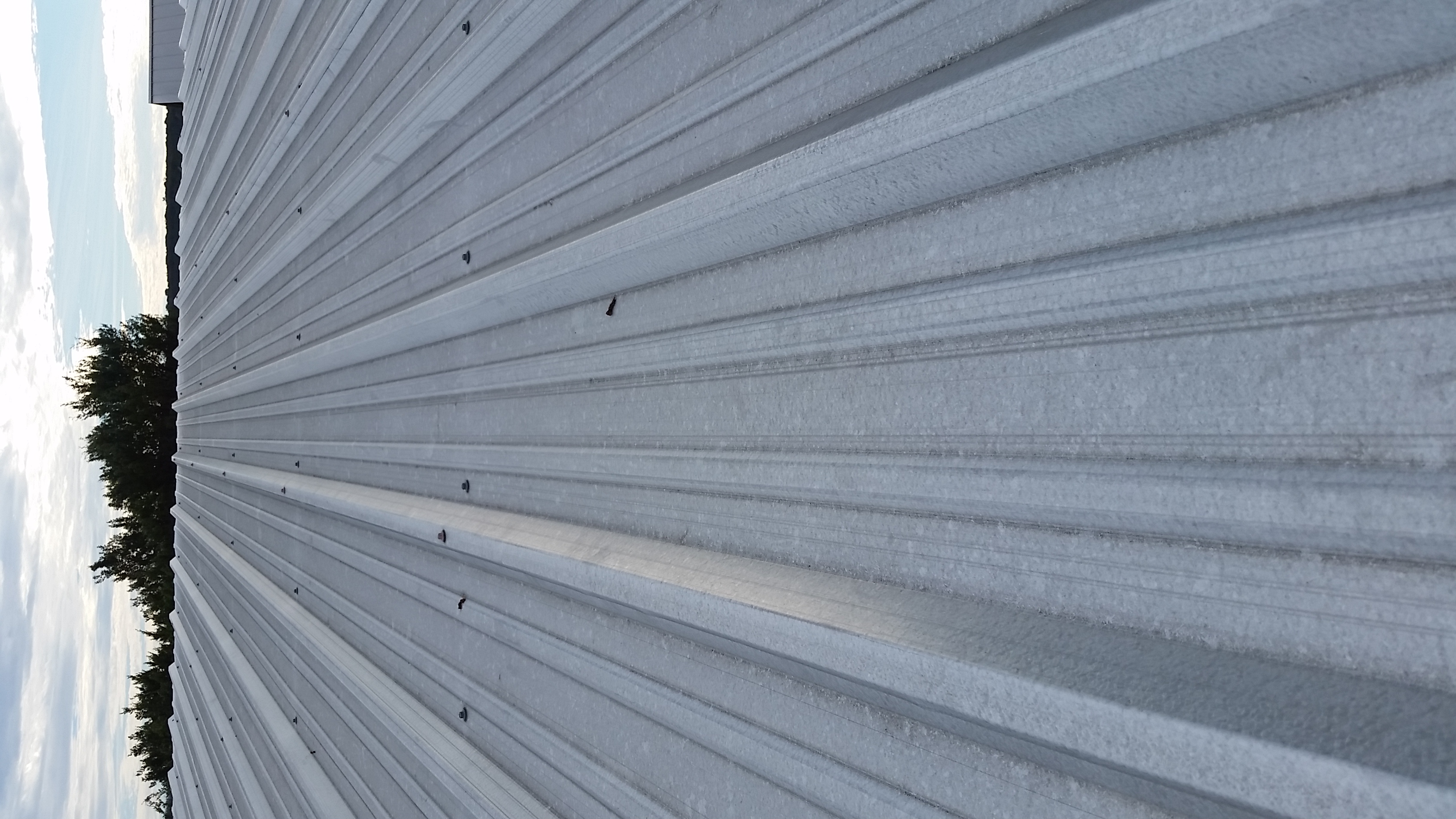 White corrugated metal roof panels installed on agricultural building — Central Texas