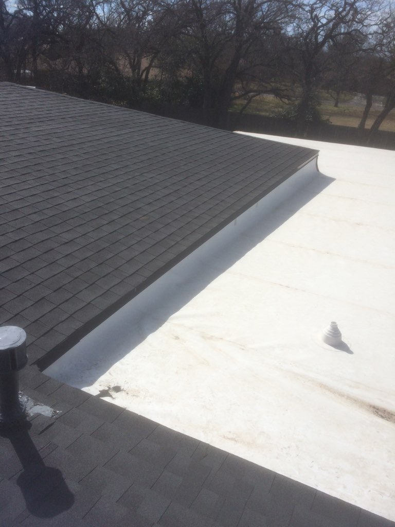 White TPO commercial flat roof with parapet edge and pipe boots — Stephenville TX