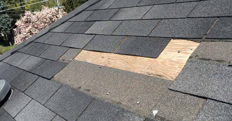 Roof decking exposed after storm-damaged shingles removed — repair in progress Heritage Roofing TX